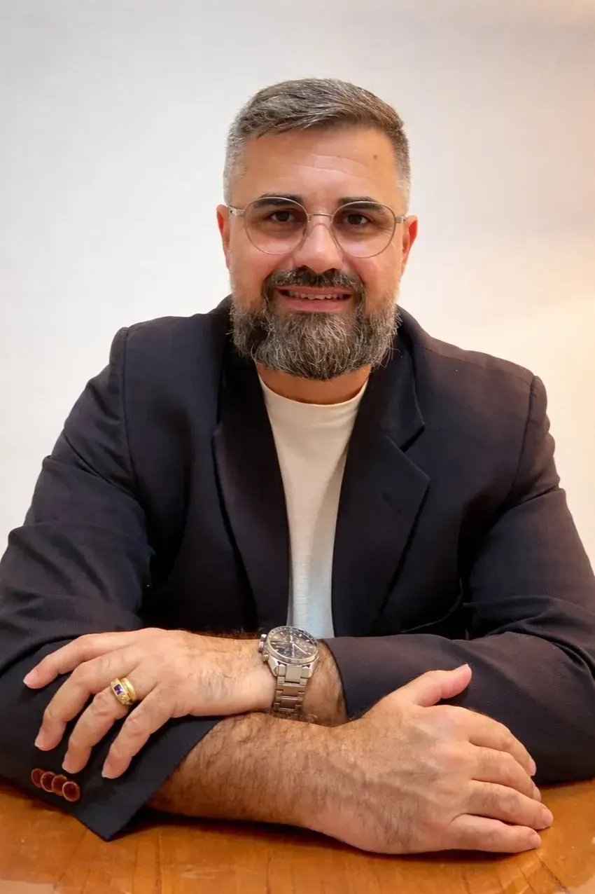 Retrato de Antônio Júnior, psicanalista clínico, sentado à mesa de seu consultório
